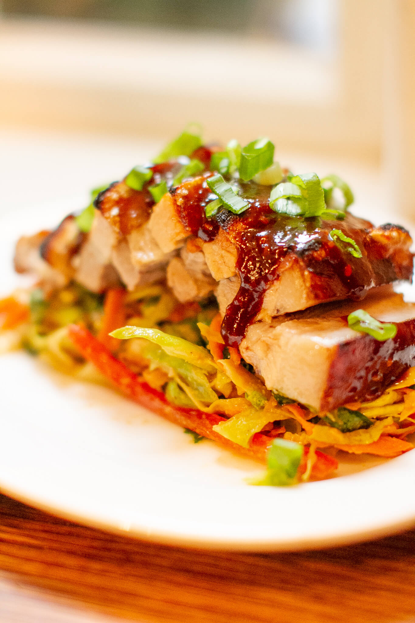 A photo of a dish with sliced pork belly with miso sauce